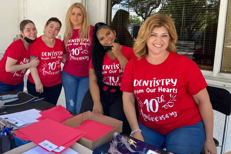 Team members wearing 10th anniversary Dentistry From Our Hearts shirts