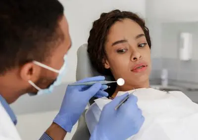 woman looking anxiously at dental mirror during an appointment