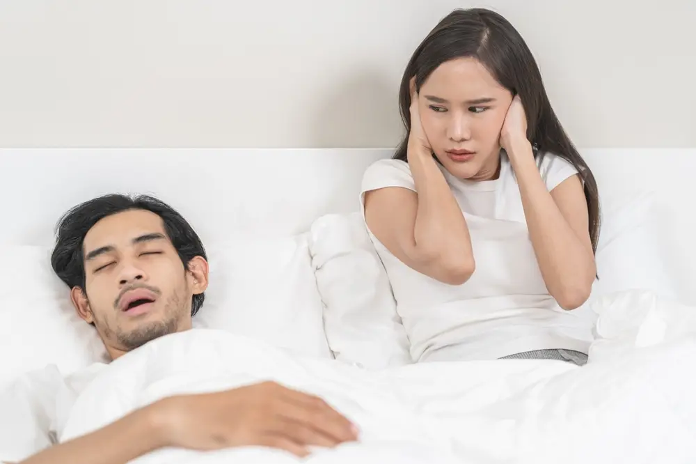 couple struggles to get sleep due to snoring and sleep apnea