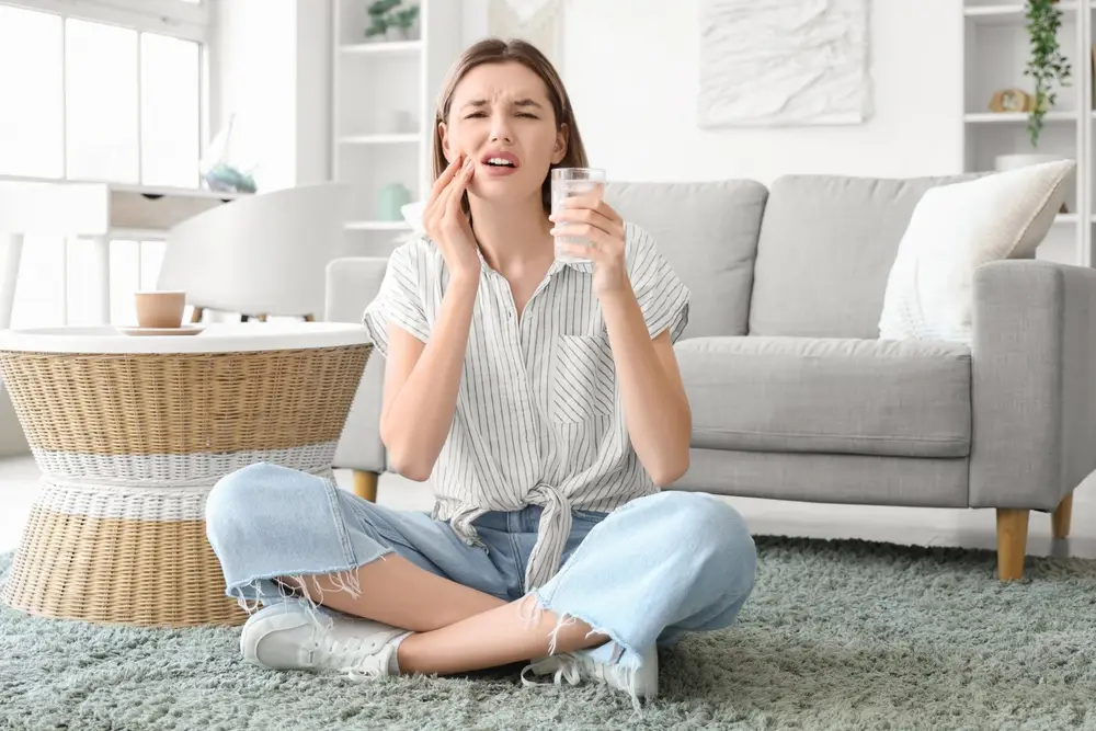 woman with sensitive teeth drinking cold milk